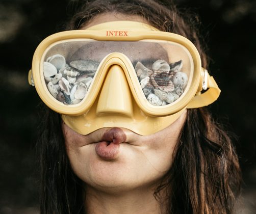 Funny woman making a face wearing goggles with shells in them